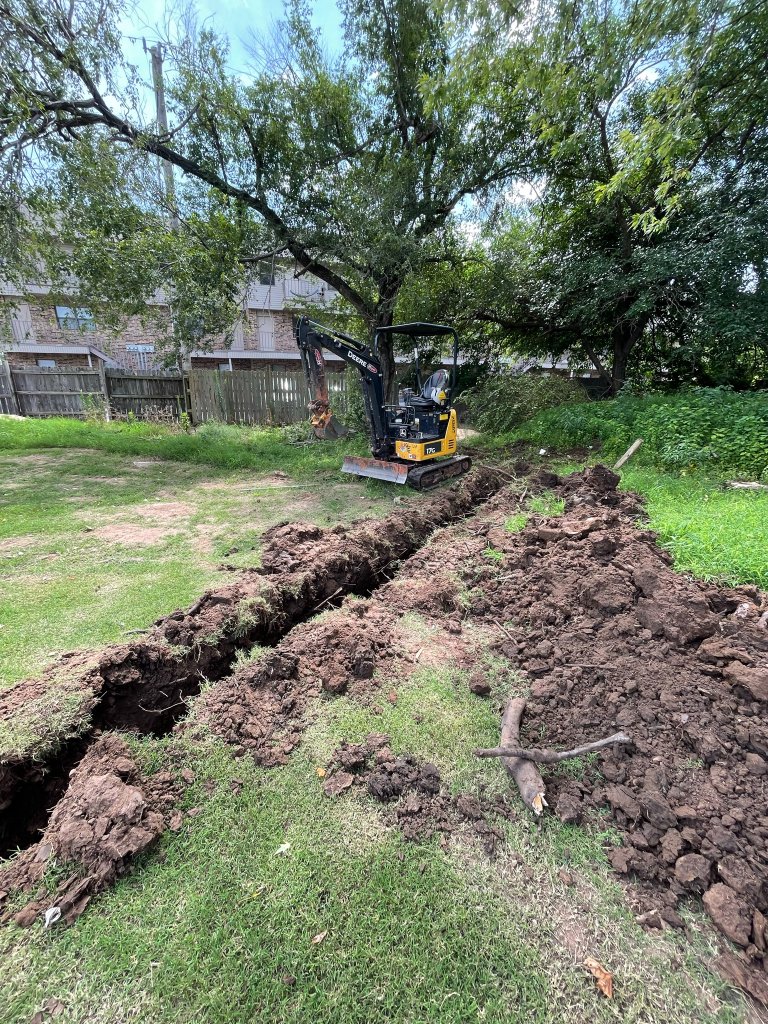 ATS excavating a drainage trench with a compact excavator in a Stillwater yard