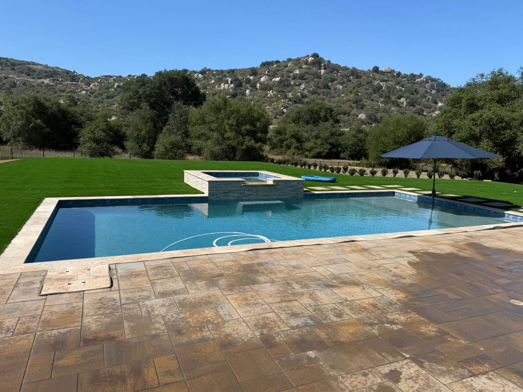 Luxury pool with paver patio and artificial turf