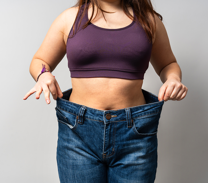 Woman showing weight loss success