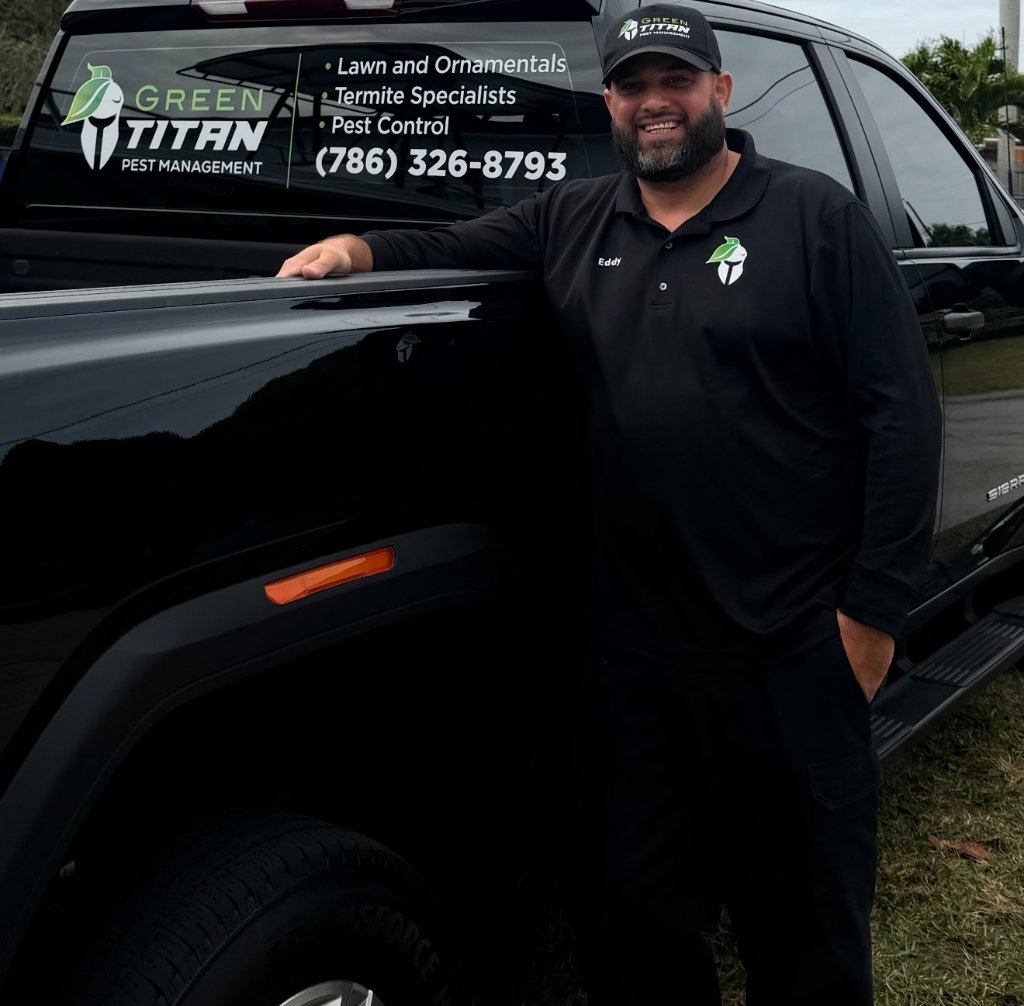 Eddy standing next to Green Titan service truck showing company branding