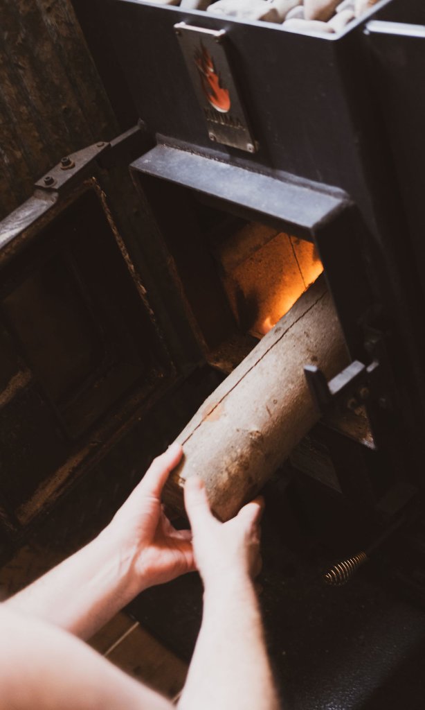 Adding wood to Kuuma stove
