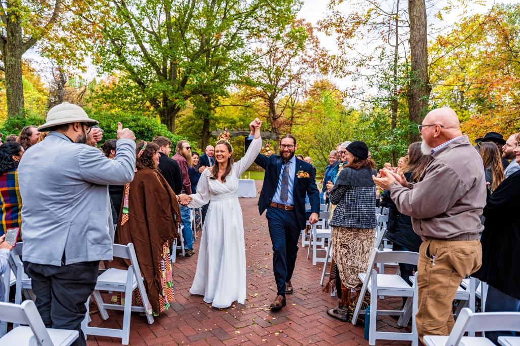 Bride and groom walking hand in hand after their outdoor ceremony in Pittsburgh