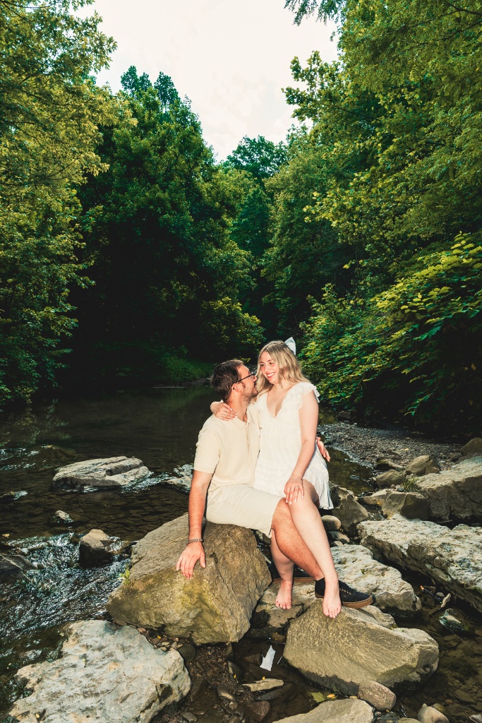Couple walking hand in hand along a wooded trail in Western Pennsylvania