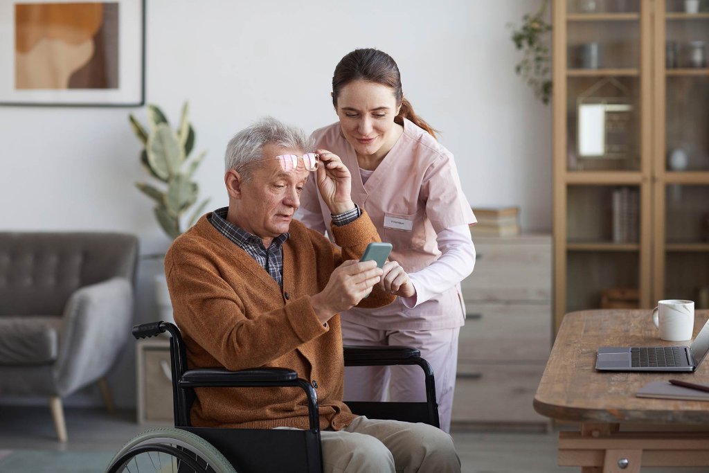 Caregiver helping senior with phone