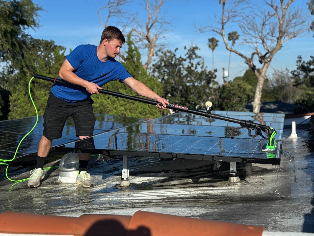 Rhine Cleaning technician pressure washing a roof