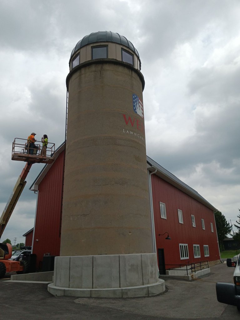 FOX Welding crew working from aerial lift platform to install custom steel observation dome on top of the property grain silo conversion