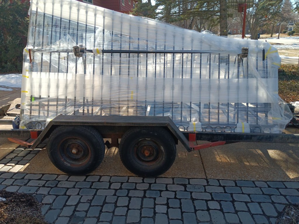 Custom fabricated ornamental iron gate panels wrapped in protective plastic and loaded on trailer for delivery and installation, Fox Valley area IL