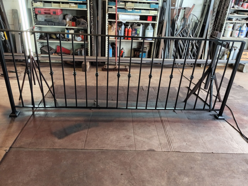 Traditional black ornamental iron railing panel with decorative collars, fabricated in shop