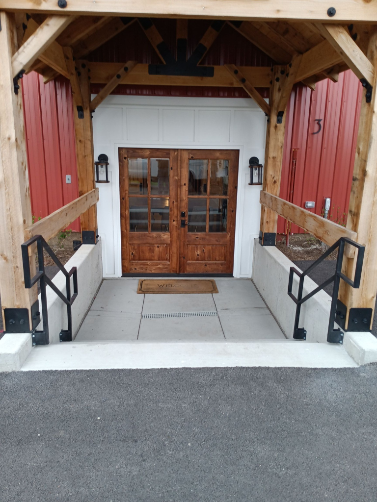Clean modern black steel entry railings at timber frame commercial building
