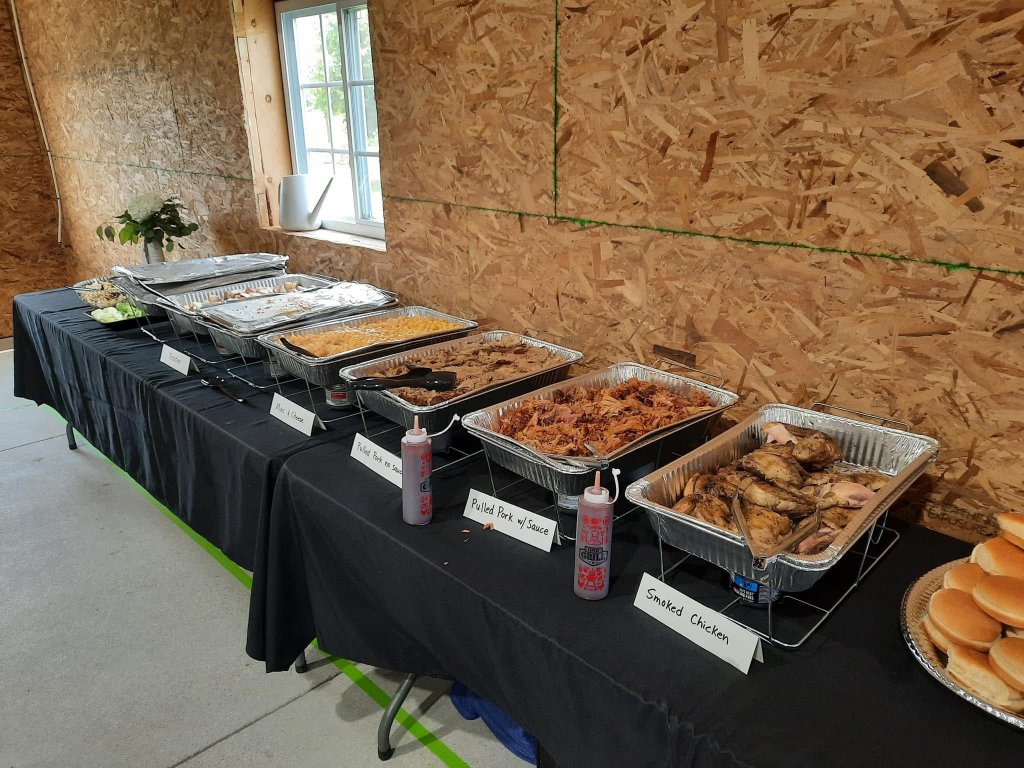 BBQ buffet catering setup with smoked meats, sides, and complete catering display