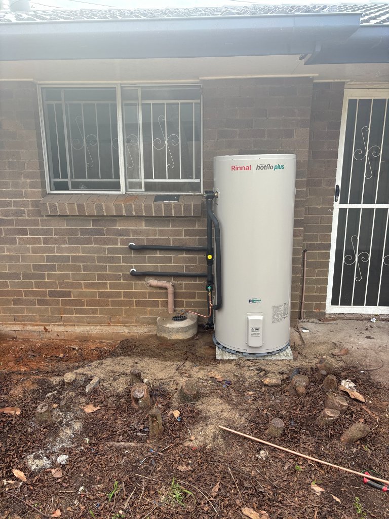 Khaki Plumbing technician installing hot water system in Brisbane Northside