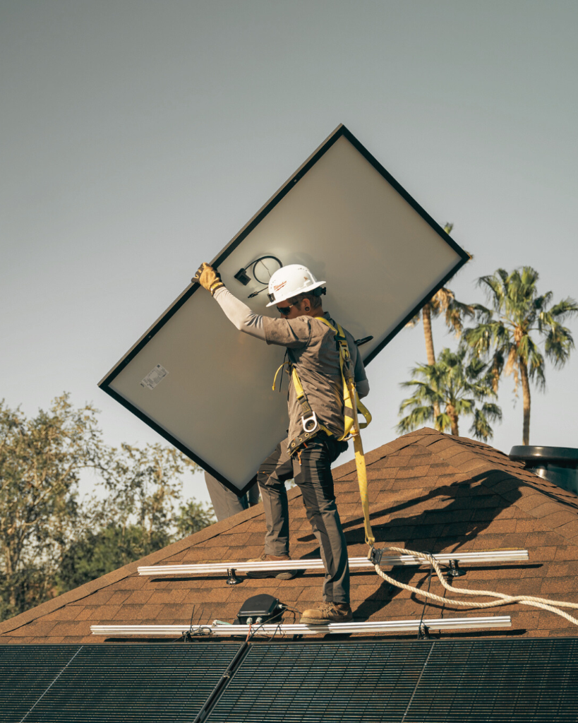 Solergy technician installing solar panel on roof