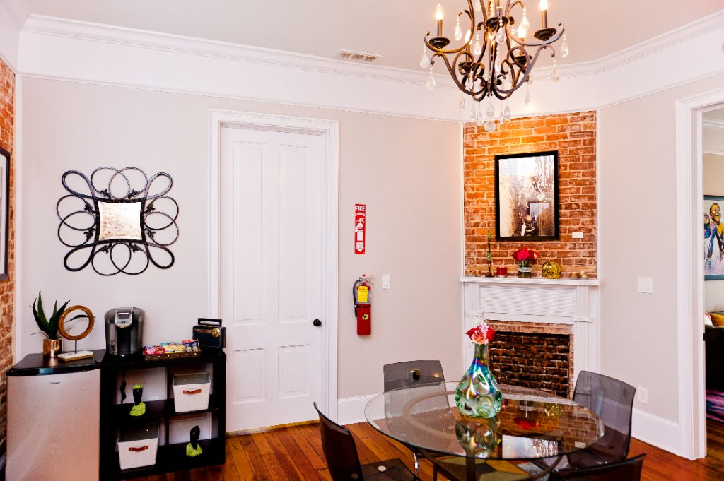 Office space with exposed brick fireplace and elegant chandelier