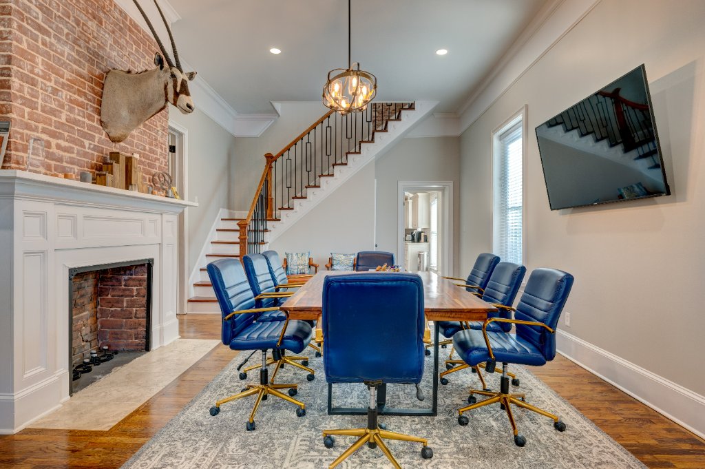 Executive boardroom with exposed brick fireplace and grand staircase