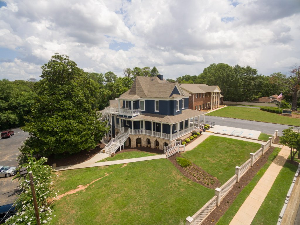 Aerial view showing the full property with parking and landscaping