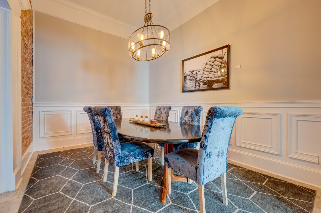 Elegant dining room with wainscoting, chandelier, and vintage photograph