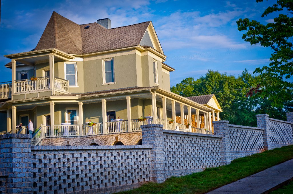 Twilight view of the restored Historic Austell House with decorative brick wall