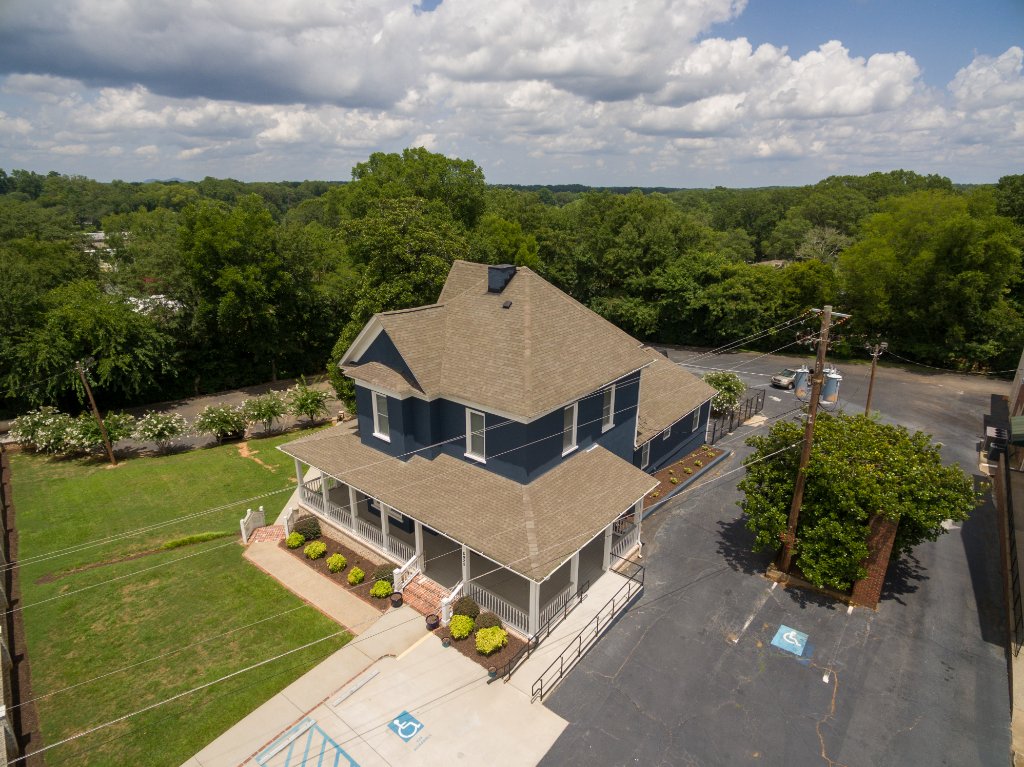 Aerial photo Historic Austell House showing side elevation with brick foundation and wraparound porch Austell GA