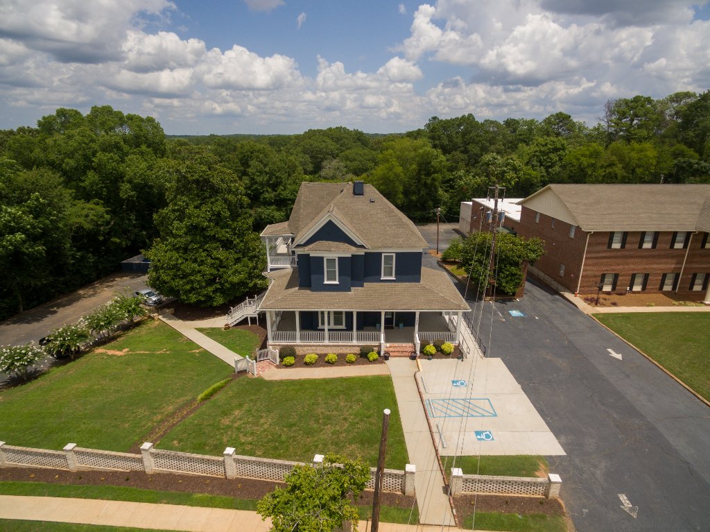 Historic Austell House bird's eye view showing blue Victorian exterior and white picket fence in Austell Georgia