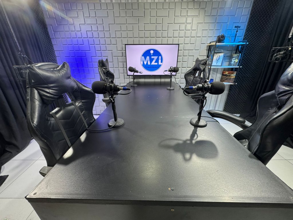 Nossa mesa de podcast, com quatro cadeiras e 4 microfones