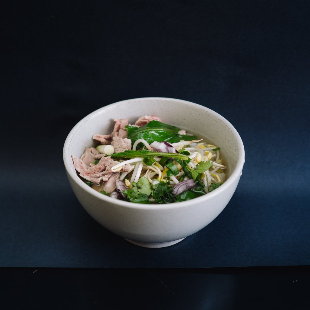 [PHOTO: Phở Bò — close-up broth with rare beef and fresh herbs]