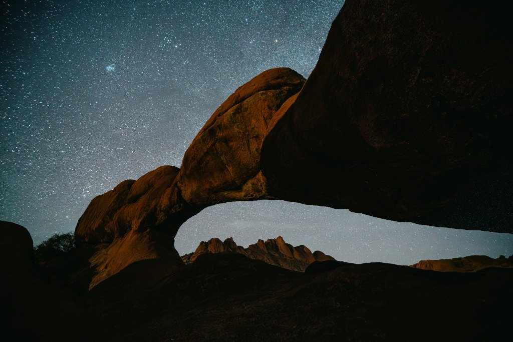 Starry night sky over mountain rocks