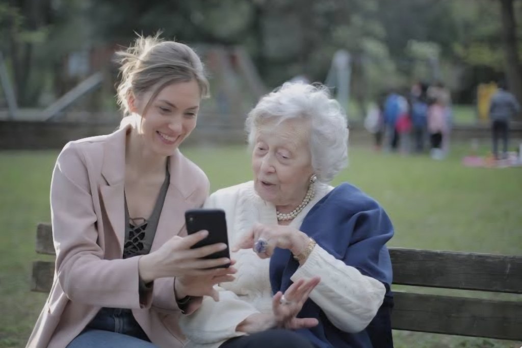 Caregiver and senior looking at phone together