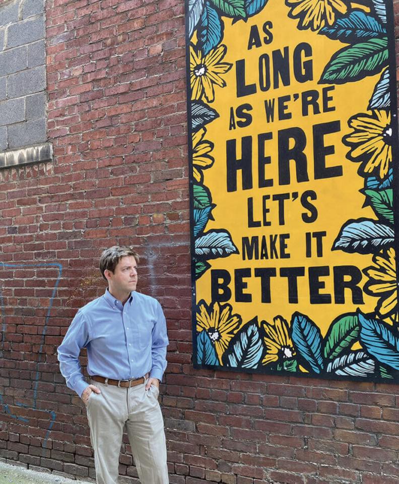 Tighe Bullock beside the West Side Wonder Mural
