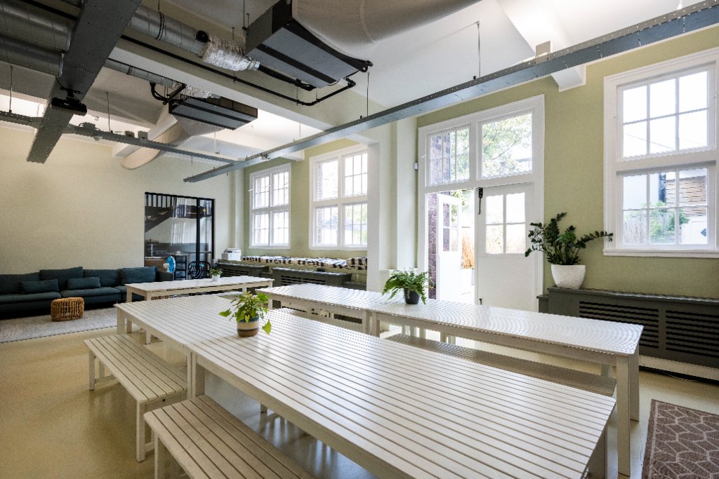 NLDS9 begane grond open werkruimte — collaboratief kantoor Amsterdam hoge plafonds daglicht
