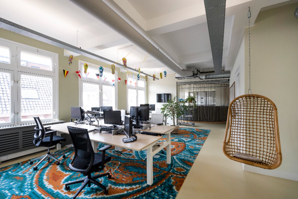 Open kantoorruimte met werkplekken en hoge plafonds, NLDS9 Amsterdam