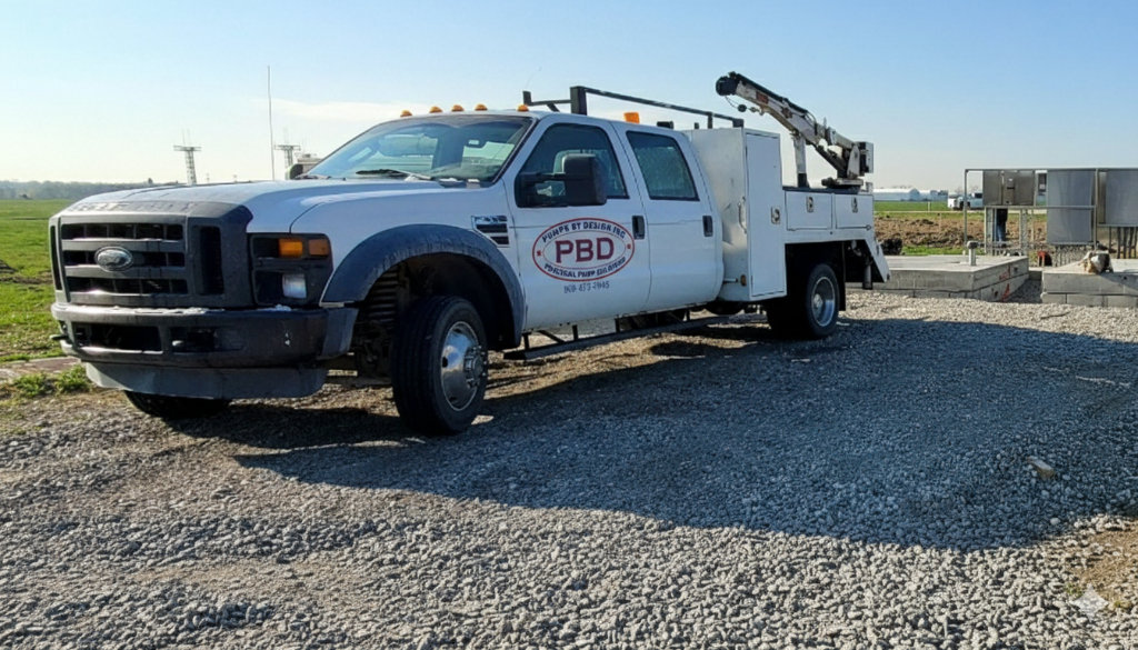 Pumps By Design service truck equipped with a crane for equipment handling.