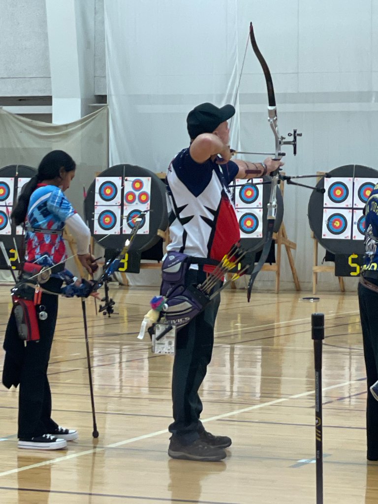 Archers competing at indoor archery tournament