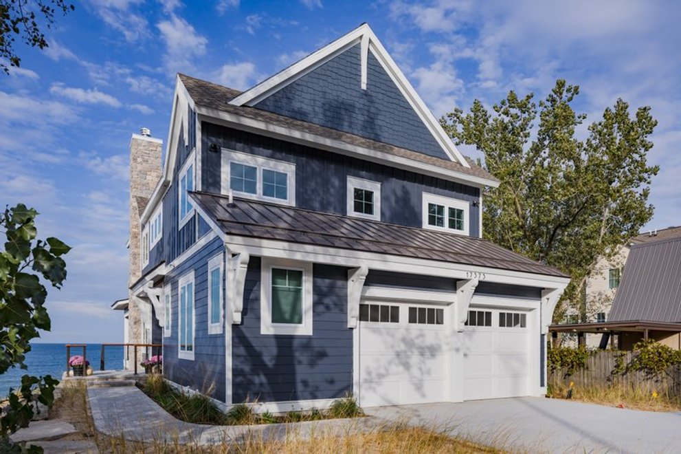 Coastal home with attached garage and ocean in the background