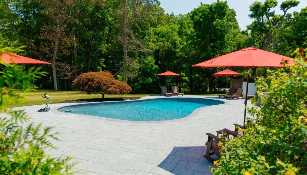 Freeform pool with red umbrellas
