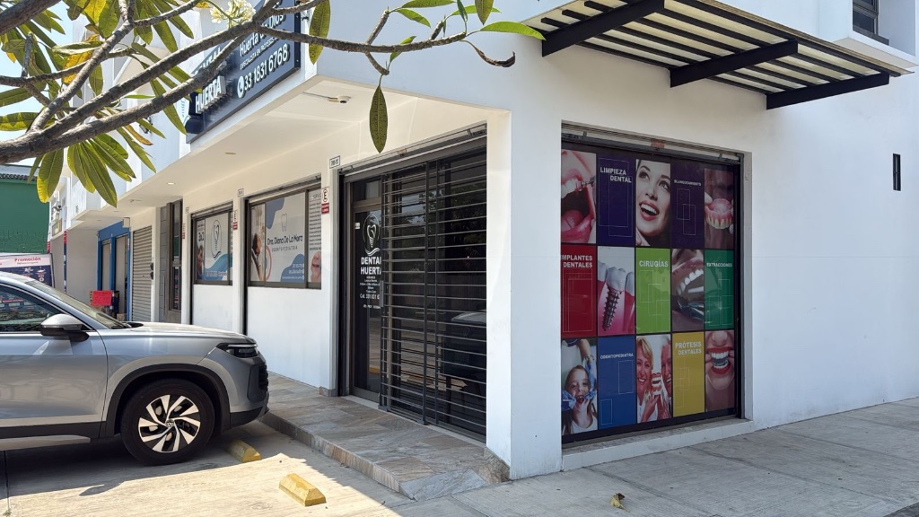Esquina exterior del edificio de DentalHuerta con rotulación de tratamientos dentales