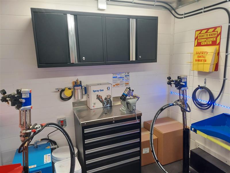 Spray foam rig workbench with gun flush pot, stainless steel countertop, and spray gun service area