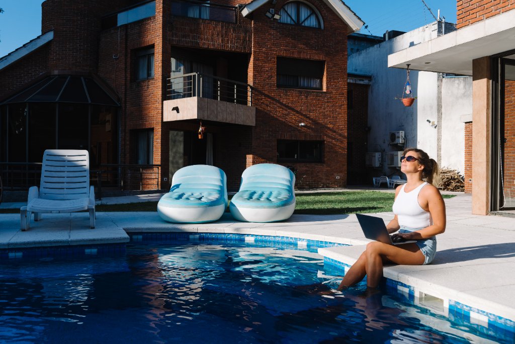 Femme avec laptop à la piscine