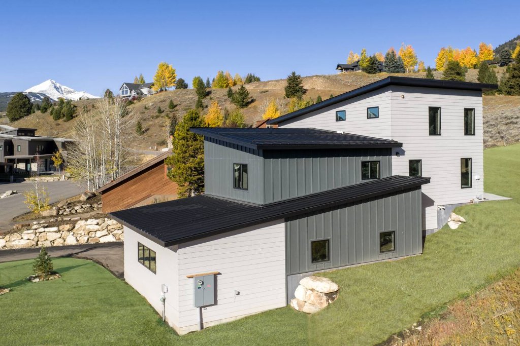 Aerial — cabin with Big Sky mountain backdrop
