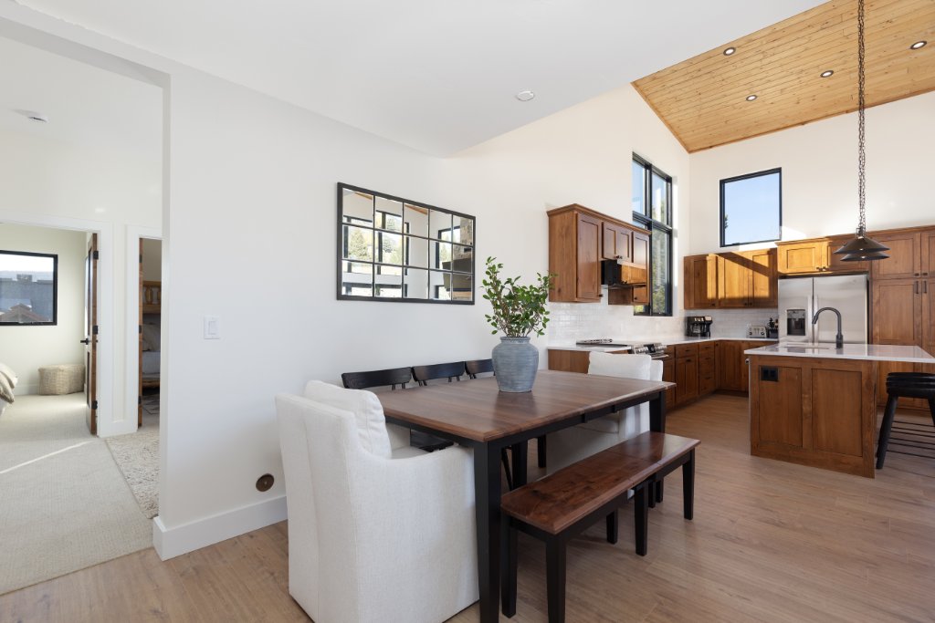 Dining room — wood table with bench & kitchen views