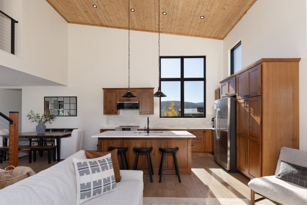 Kitchen — open to living room with vaulted wood ceiling & bar stools