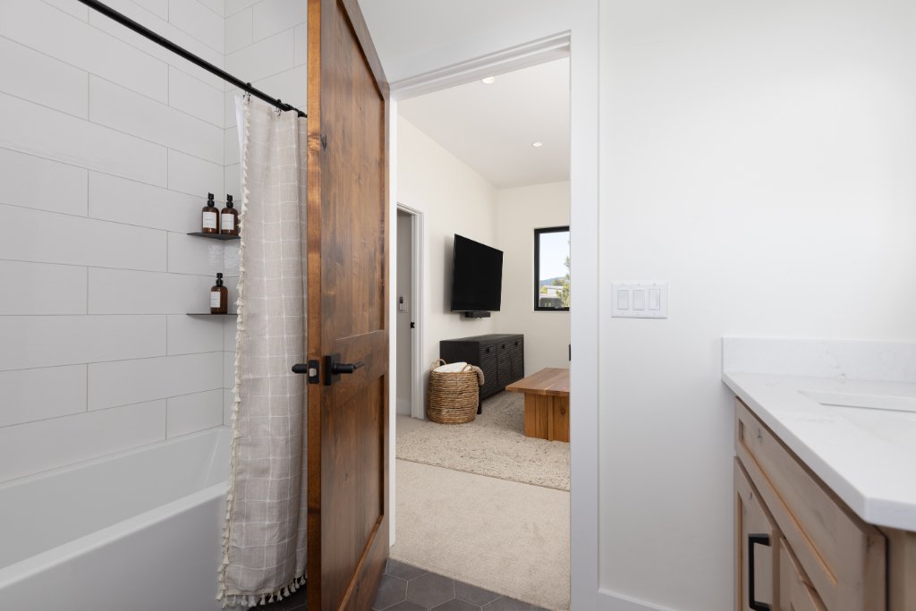 Bathroom 3 — tub/shower with barn door entry to family room