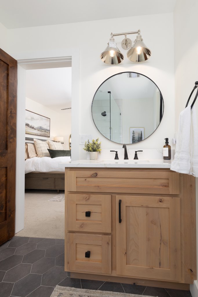 Bathroom 2 — round mirror & wood vanity