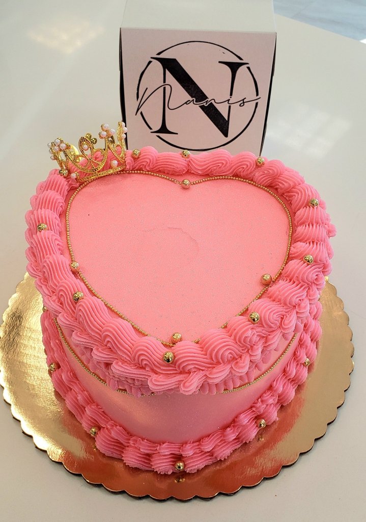 Pink heart-shaped cake with crown topper