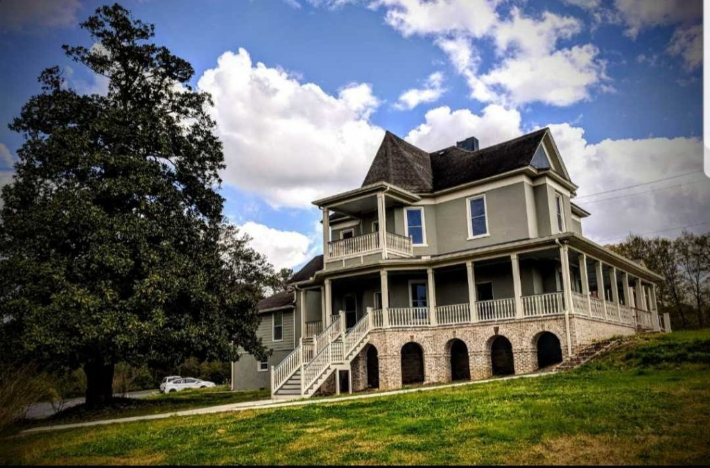 Historic Austell House - Restored Victorian exterior with wraparound porch and grand magnolia tree
