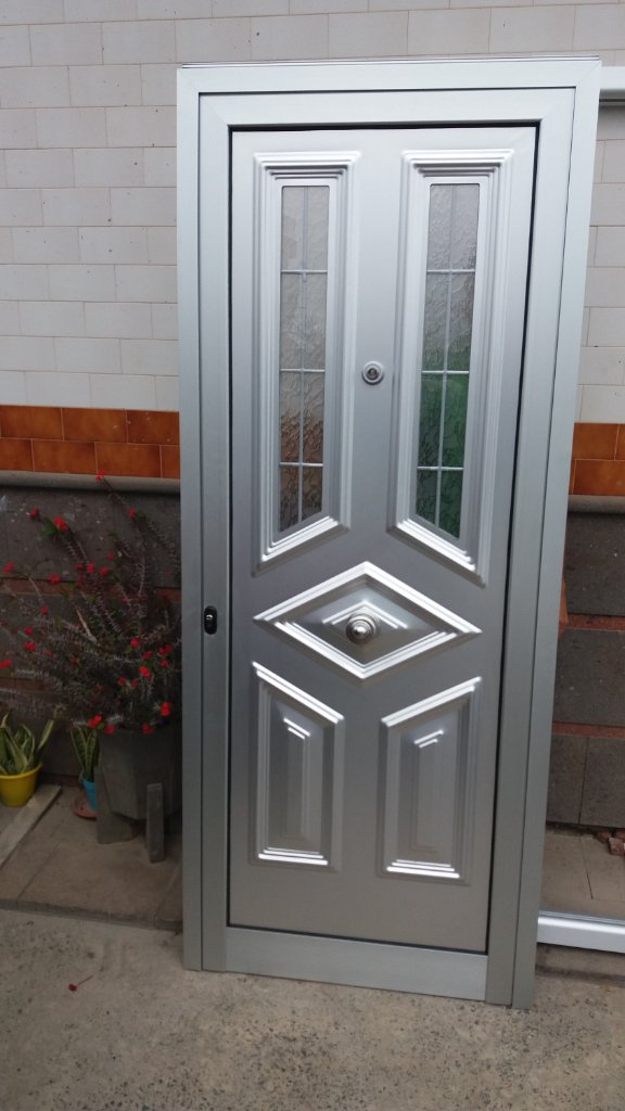 Puerta de aluminio marrón con montante de cristal