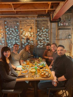 A team dinner round a long table in a warm, low-lit restaurant