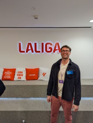 Standing beside a large LALIGA sign at the entrance to the building