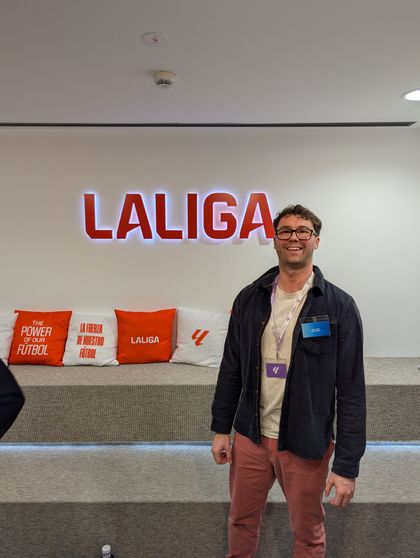 Standing beside a large LALIGA sign at the entrance to the building