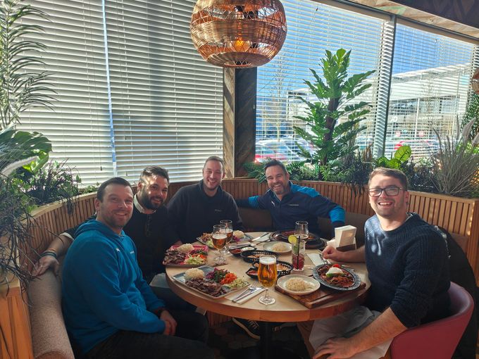 The Play Fund Win team round an outdoor table on a roof terrace, plates everywhere