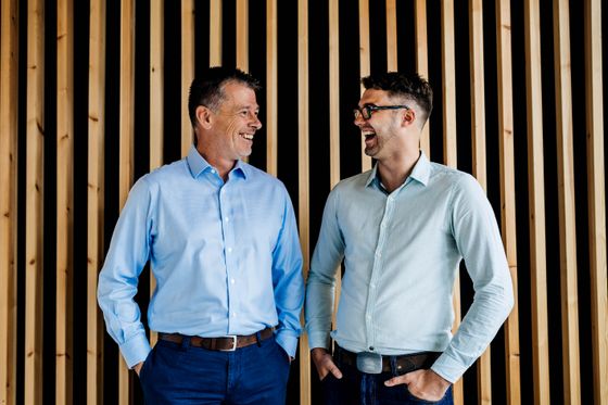 A Trusted Media photograph: two colleagues standing together in an office, talking